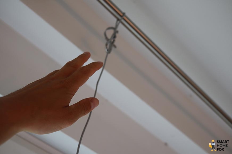 Das Sicherungsseil des Ecovacs WINBOT W1 PRO wird an der Gardinenstange befestigt